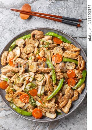 Moo goo gai pan is an American-Chinese classic a hearty mix of chicken and mushrooms closeup on the plate on the table. Vertical top view Moo goo gai pan is an American-Chinese classic a hearty mix of chicken and mushrooms closeup on the plate on the table. Vertical top view 115293572