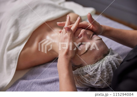 Modern Cosmetology, Cosmetic Enzyme, Facial Rejuvenation. Enzyme mask and retinol facial treatment are applied with precision using facial brush for optimal peeling results. 115294084