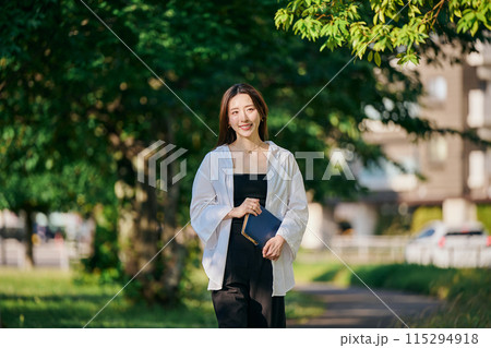 手帳を持って歩く若い女性 手帳を持って歩く若い女性 115294918