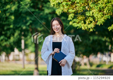 手帳を持って歩く若い女性 手帳を持って歩く若い女性 115294920