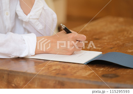 リビングで家族への手紙を書くミドル女性 115295593