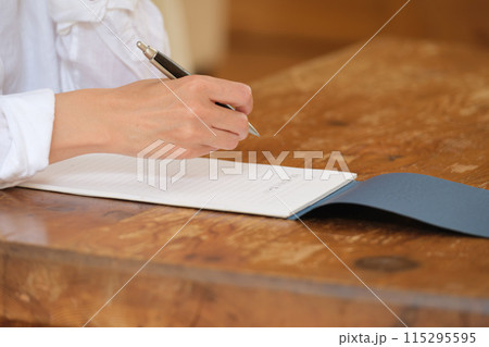 リビングで家族への手紙を書くミドル女性 リビングで家族への手紙を書くミドル女性 115295595