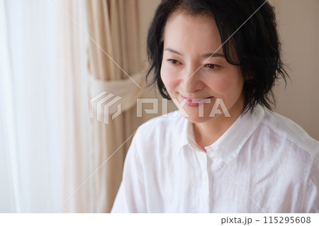 リビングで家族への手紙を書くミドル女性 115295608