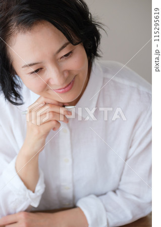 リビングで家族への手紙を書くミドル女性 リビングで家族への手紙を書くミドル女性 115295619