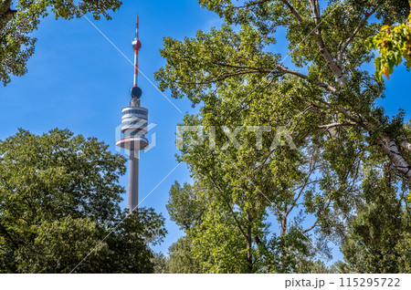 Vienna, Austria, August 17, 2022. The Danube Tower or Donauturm is the tallest building in Austria at 252 metres. It stands out among the trees of the park. 115295722