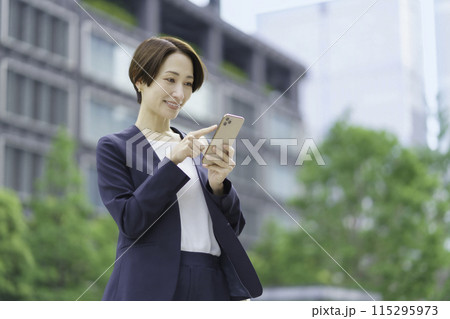 スマホを操作するオフィス街のビジネスウーマン 115295973