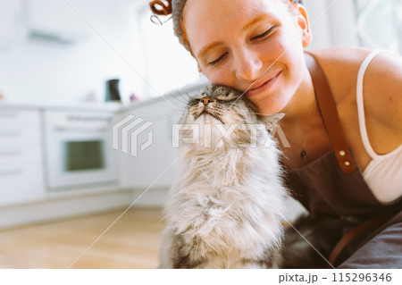 Portrait red-haired curly young woman with beloved fluffy domestic cat Portrait red-haired curly young woman with beloved fluffy domestic cat 115296346