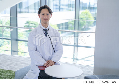 病院で笑顔で問診する男性医師 病院で笑顔で問診する男性医師 115297189