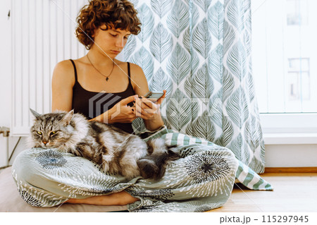Big gray fluffy cat on lap of teenager girl Big gray fluffy cat on lap of teenager girl 115297945