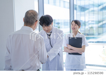 握手する男性医師と看護師と患者 115298590