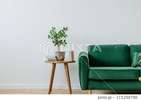 Minimalist living room with a clean and cozy aesthetic, featuring a green fabric sofa 115298786