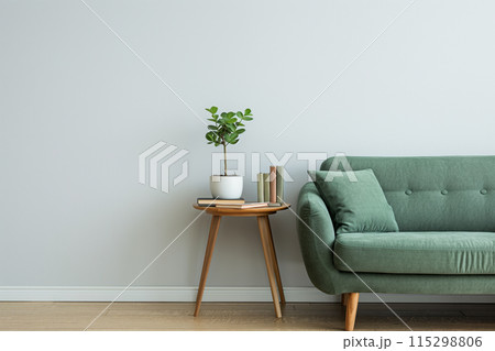 Minimalist living room with a clean and cozy aesthetic, featuring a green fabric sofa 115298806