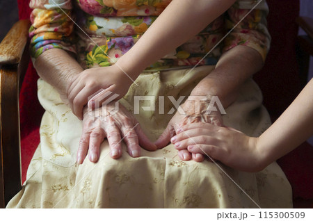 Female senior old hands and child's hands - selective focus. Female senior old hands and child's hands - selective focus. 115300509