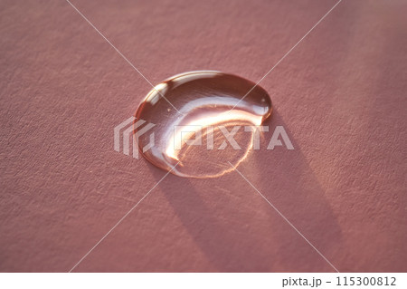 Beautiful volumetric drop of cosmetic product on a pink background. Beautiful volumetric drop of cosmetic product on a pink background. 115300812