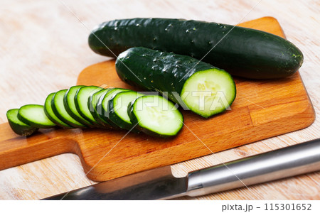 Many ripe cucumbers on wooden surface 115301652