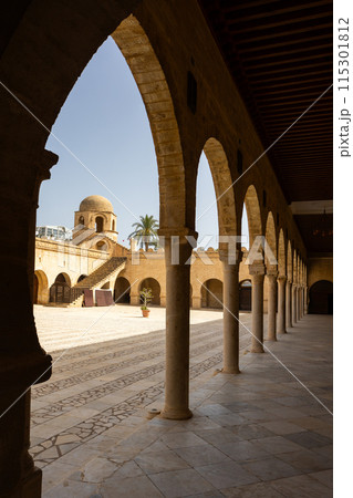 View from shaded archway onto courtyard of Great Mosque of Sousse with domed tower View from shaded archway onto courtyard of Great Mosque of Sousse with domed tower 115301812
