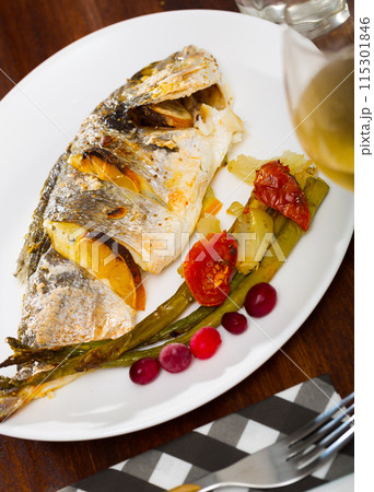 Roasted dorada with baked vegetables and cranberries 115301846