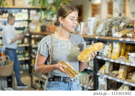 Young girl purchaser buying pasta in grocery store 115301982