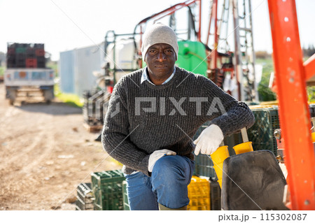 Male tractor driver in farm backyard Male tractor driver in farm backyard 115302087