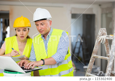 Construction workers working at house being renovated 115302400
