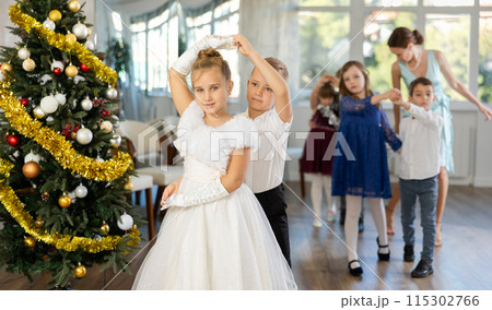 Viennese waltz performed by beautifully dressed children near Christmas tree 115302766