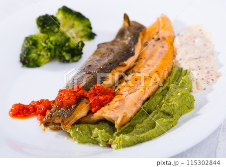 Tasty steak of fried river trout fillet with broccoli and sause tartar on plate 115302844
