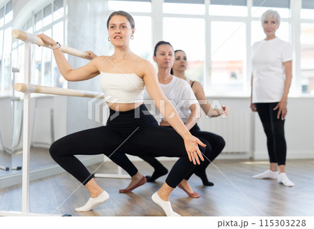 Elderly woman teacher corrects female dancers 115303228