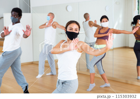 Woman in protective mask enjoying active dancing during group training 115303932