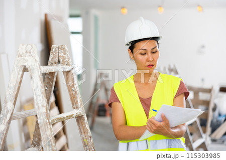 Woman engineer checking documents during repair works Woman engineer checking documents during repair works 115303985