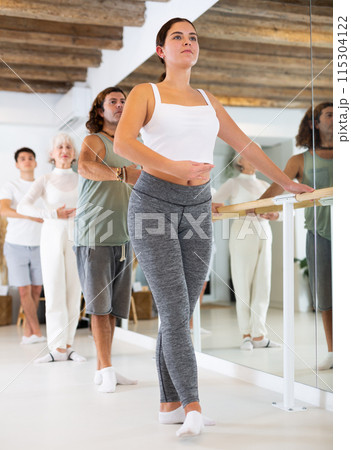 Young woman doing ballet at barre 115304122
