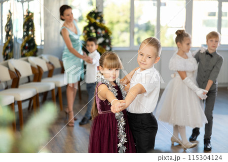 Little children in festive clothes dance foxtrot dance while celebrating Christmas 115304124