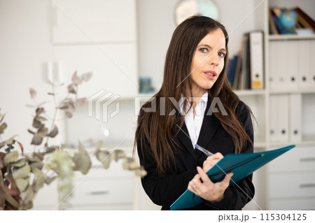 Woman secretary holding folder and looking at camera 115304125