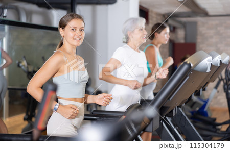 Young woman exercising on treadmill in gym Young woman exercising on treadmill in gym 115304179