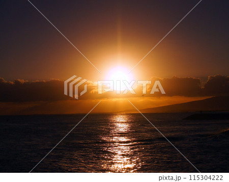 Dramatic Sunset over the clouds and reflecting on the Pacific ocean on the water with airplane 115304222