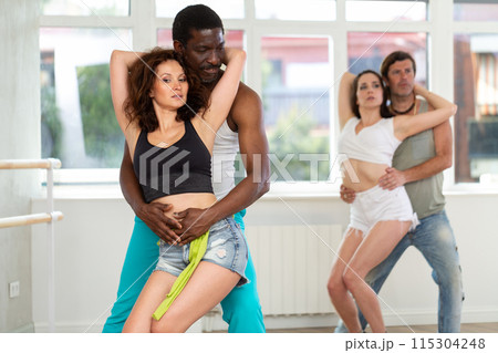 Adult couple enjoying impassioned merengue in latin dance class 115304248