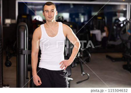 Sportive young man posing in gym Sportive young man posing in gym 115304632