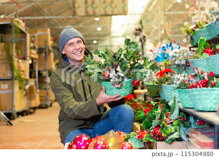 Man choosing christmas decorations on sale in shop 115304980