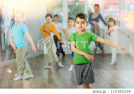 Group of happy preteen children with female teacher practicing hip hop in dance studio Group of happy preteen children with female teacher practicing hip hop in dance studio 115305239