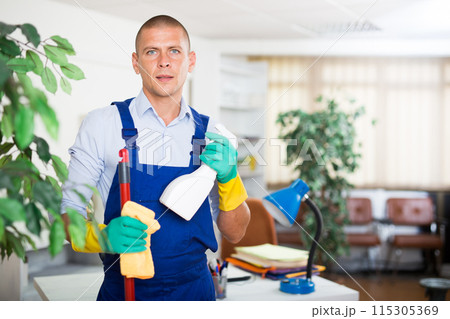 Professional cleaner in uniform ready for cleaning in office 115305369