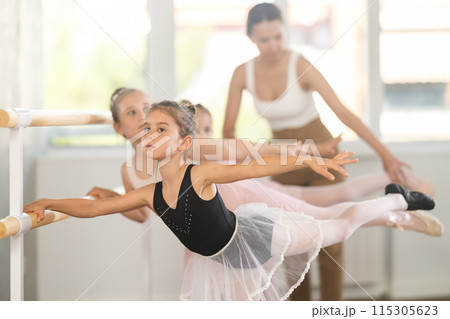 Little girls ballet lovers learn to perform arabesque pose in choreography studio 115305623