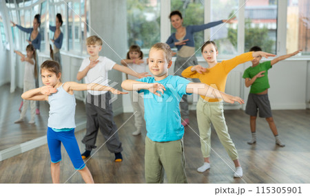 Energetic children practicing modern vigorous movements in dance class 115305901