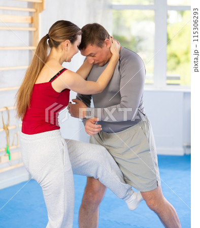Young girl practicing feet kick method of self-defense in pair with middle-aged man 115306293