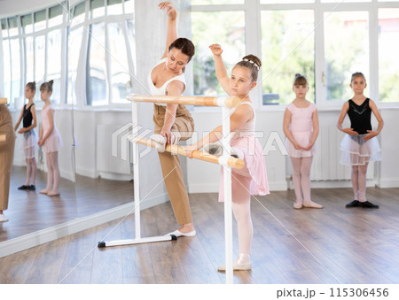 Little ballerinas together with choreography teacher in grand batman pose learn to dance ballet 115306456