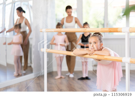 Girl dancer resting at ballet barre Girl dancer resting at ballet barre 115306919