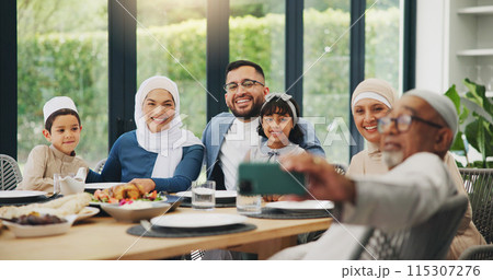 Muslim, family and eating food with selfie for eid mubarak in living room of house for celebration. Islamic, memory and festival with dinner in lounge of home for culture or tradition after ramadan Muslim, family and eating food with selfie for eid mubarak in living room of house for celebration. Islamic, memory and festival with dinner in lounge of home for culture or tradition after ramadan 115307276