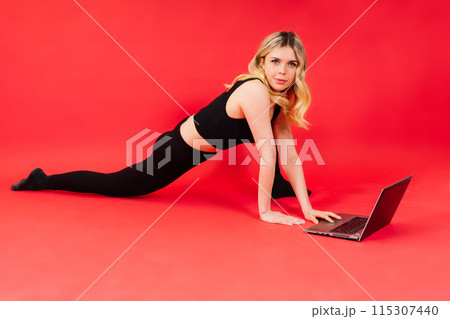 Happy young female do exercises before laptop screen at home or in gymnastic studio. Happy young female do exercises before laptop screen at home or in gymnastic studio. 115307440