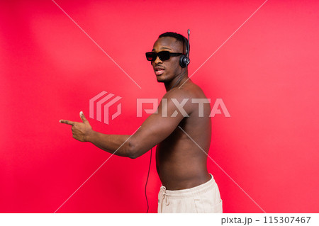 Like what you see. A handsome and muscular young man posing in the studio. 115307467