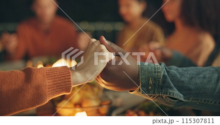 Closeup, holding hands and praying, food and friends worship together, gratitude and thanks to God at dinner party. Men, women with nutrition and religion, celebration and social event at night 115307811