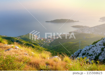 Aerial view of Budva Riviera from Fort Kosmach at sunset. Old fortress ruins is located in mountains near Budva in Montenegro. Amazing panoramic landscape of Adriatic coast with Saint Nikolay Island 115308623