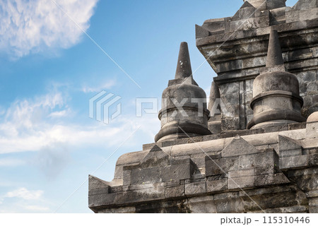 A large stone building with a blue sky in the background A large stone building with a blue sky in the background 115310446